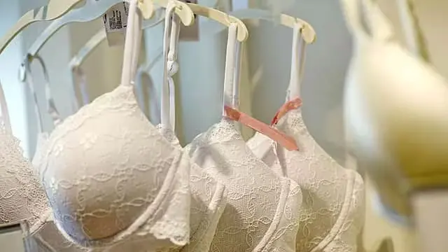 A group of white bras hanging on the wall.