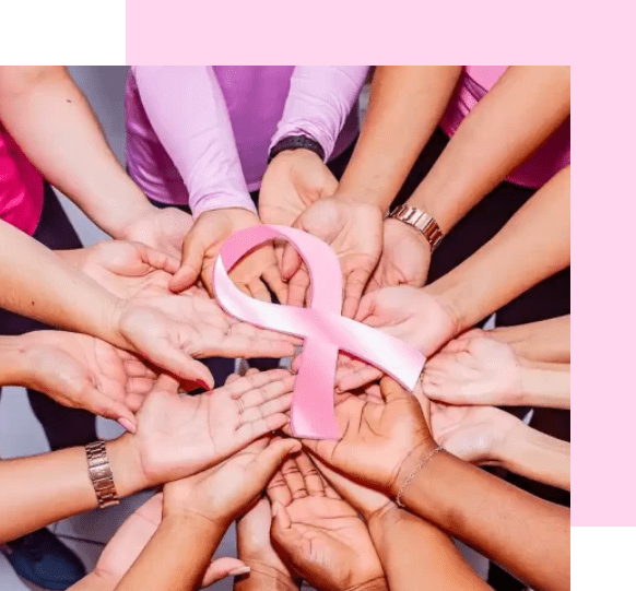 A group of people holding hands around a pink ribbon.